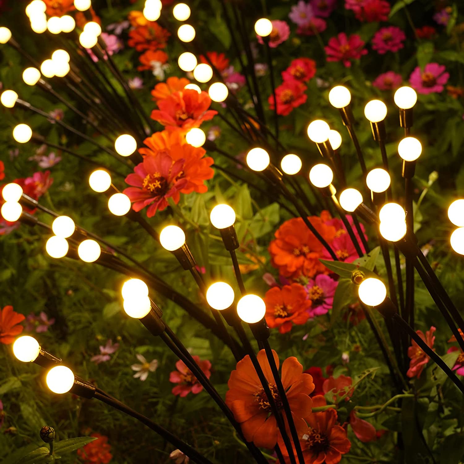 Solcelle ildflue lamper blandt blomsterne i bedet